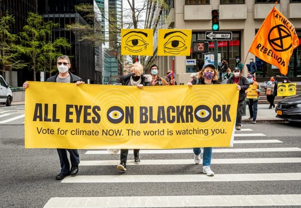 Climate activists march with a banner that says 'All Eyes on BlackRock' in new york city